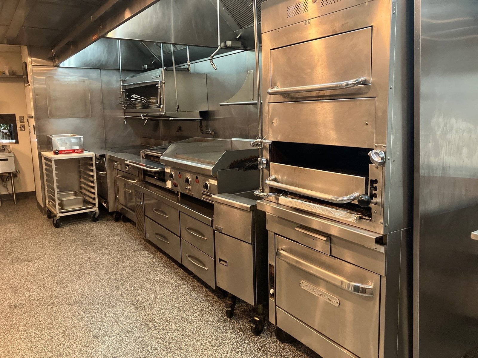 Dauphine's finished deck oven and griddle cook line under hood — NLI install