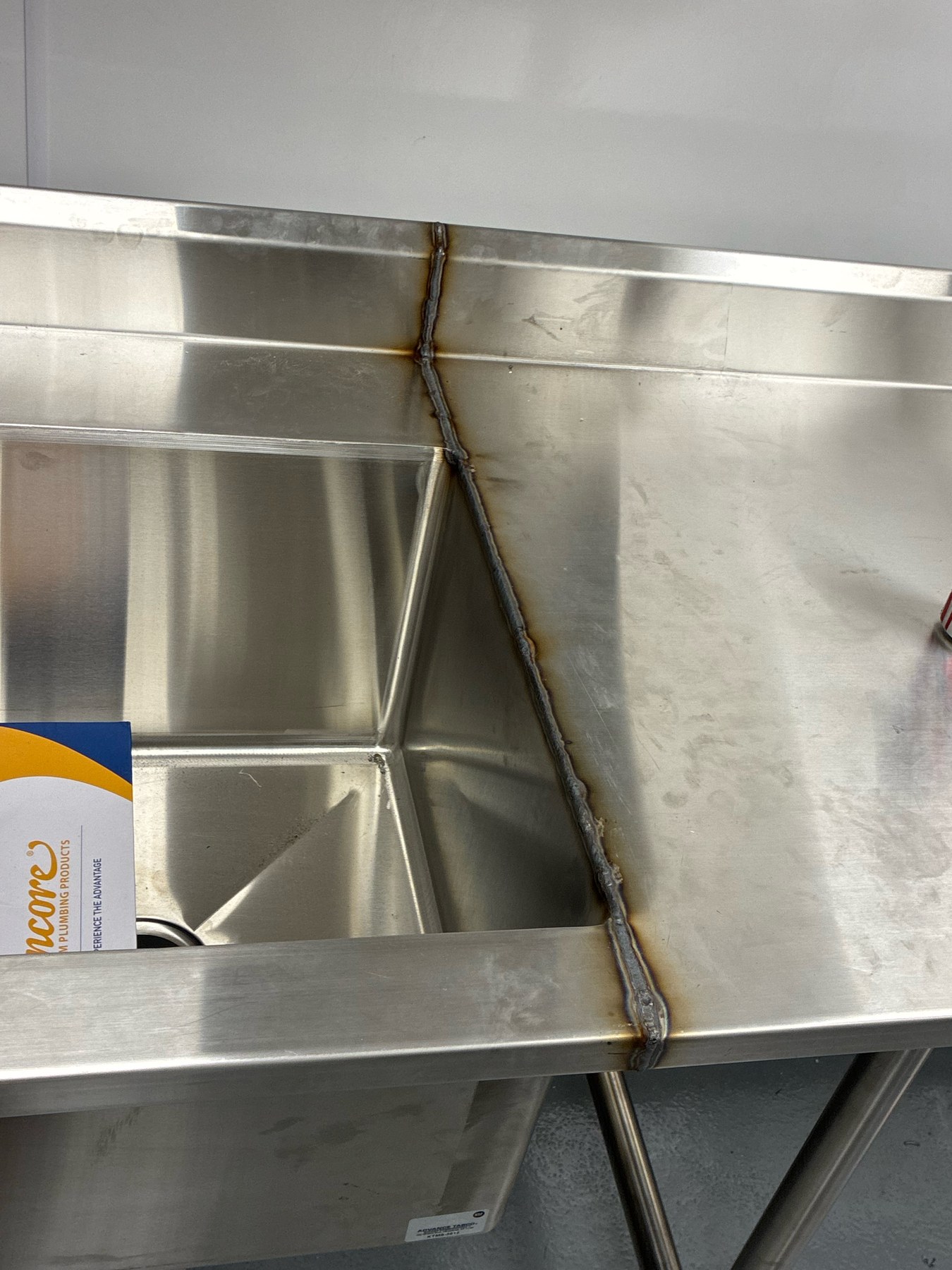 Stainless steel sink and counter weld during commercial kitchen fabrication — NLI